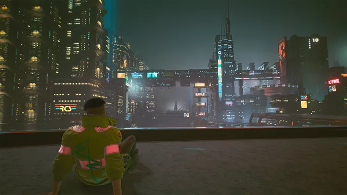 A landscape of Night City as a protagonist sits on a rooftop in Cyberpunk 2077.